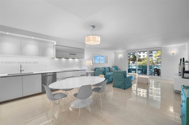 dining area featuring sink, light tile floors, and a chandelier