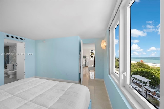 bedroom with a water view, connected bathroom, and tile flooring