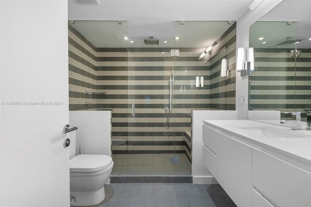 bathroom featuring a shower with door, vanity, and toilet