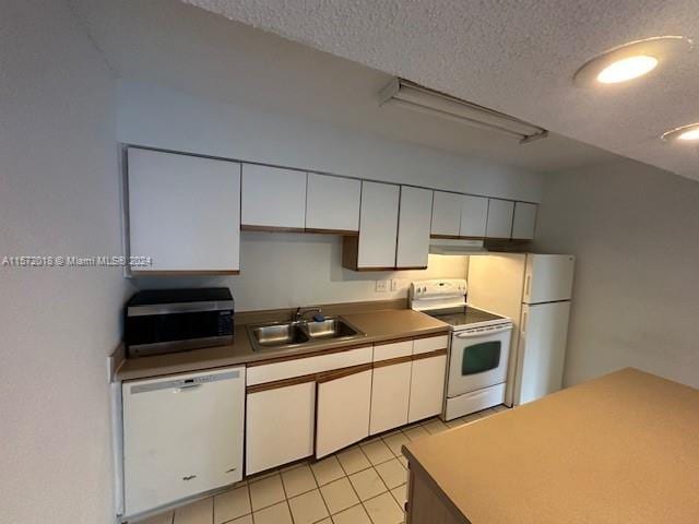 3985 W Mcnab Rd Unit A111, Pompano Beach, FL 33069 - kitchen featuring white appliances, a sink, a textured ceiling, white cabinets, and light tile patterned flooring