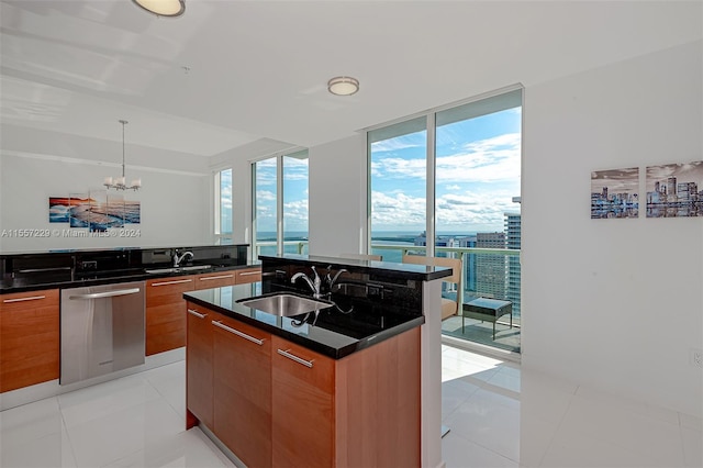 kitchen featuring a kitchen island with sink, sink, pendant lighting, an inviting chandelier, and light tile floors