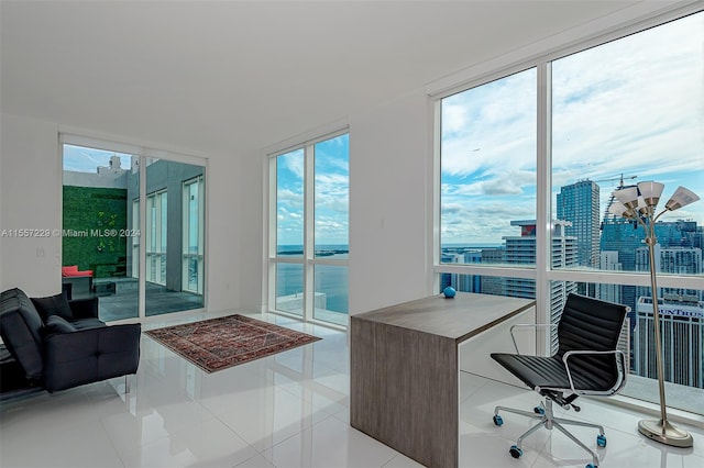 tiled home office featuring a water view and a wall of windows