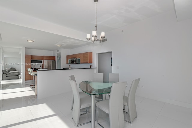 tiled dining space featuring an inviting chandelier