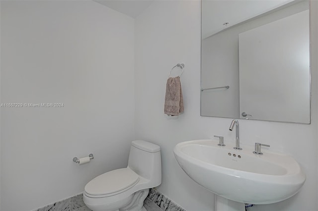 bathroom with sink, tile floors, and toilet