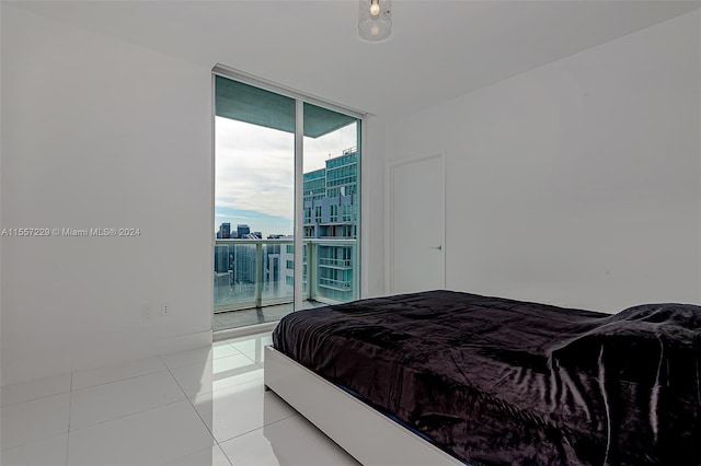 tiled bedroom with expansive windows and access to outside