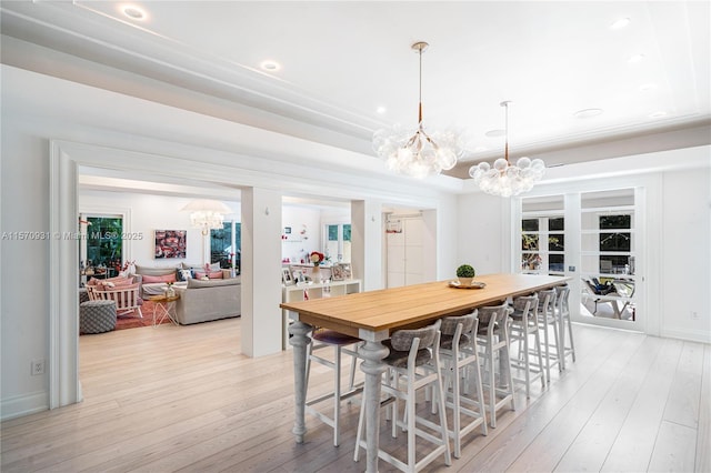 dining room featuring light wood-type flooring and a notable chandelier