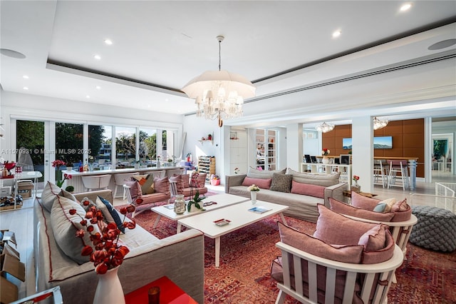 living room with a raised ceiling and a notable chandelier