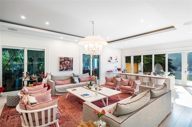 living room featuring hardwood / wood-style flooring, french doors, plenty of natural light, and a notable chandelier