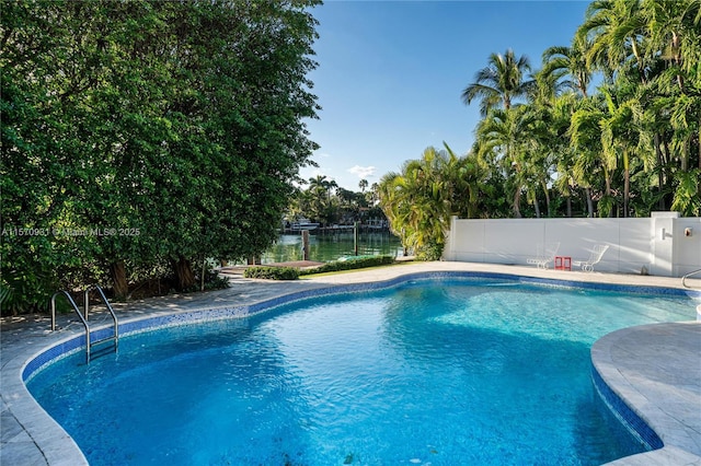 view of swimming pool featuring a patio and a water view