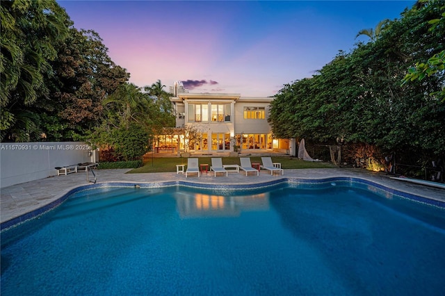 pool at dusk with a patio