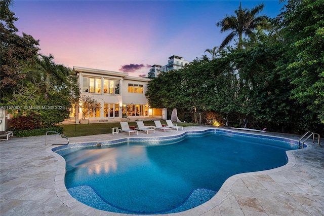 pool at dusk with a patio