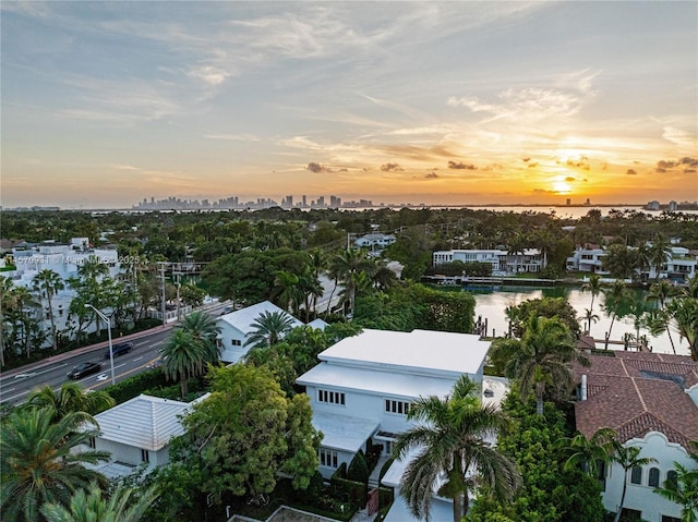 aerial view at dusk featuring a water view