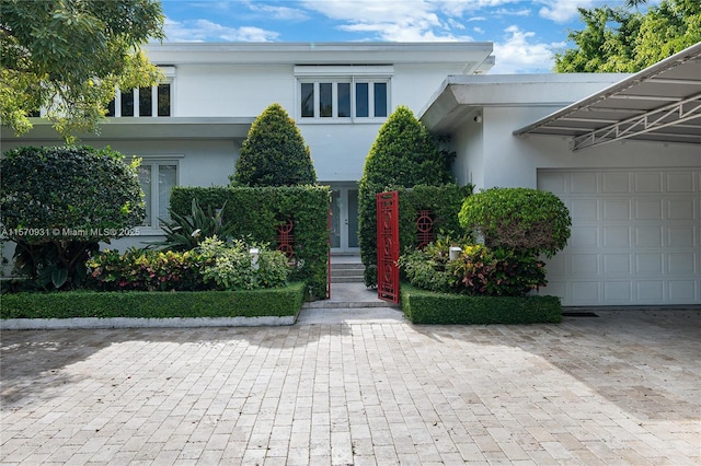 6320 Allison Rd, Miami Beach, FL 33141 - view of front facade featuring stucco siding, an attached garage, and driveway