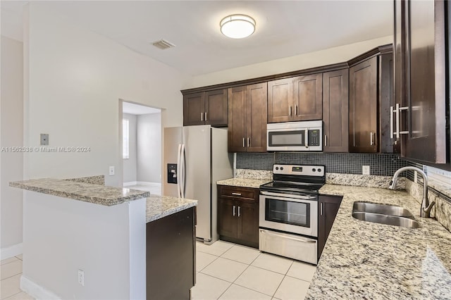 kitchen featuring tasteful backsplash, appliances with stainless steel finishes, sink, and light stone counters