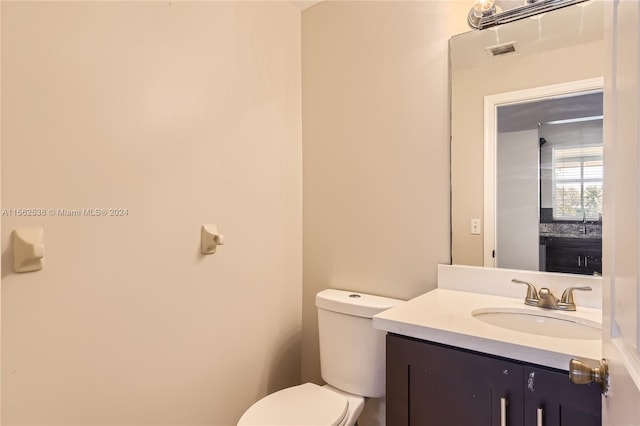 bathroom with vanity with extensive cabinet space and toilet