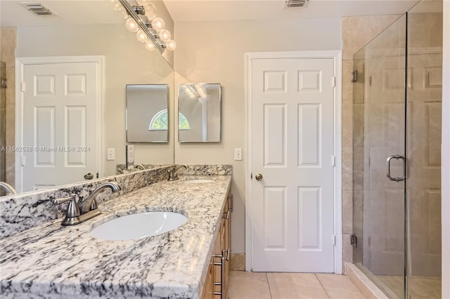 bathroom with vanity with extensive cabinet space, tile floors, and walk in shower