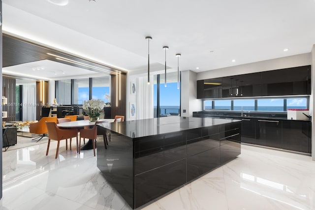 kitchen with sink, hanging light fixtures, light tile floors, and a kitchen island