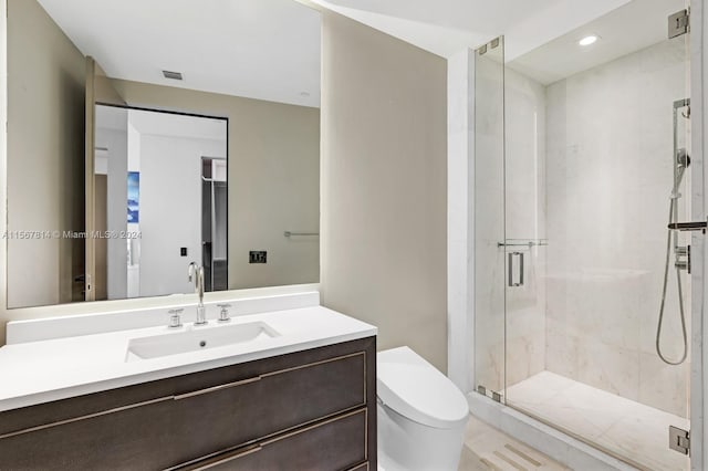 bathroom with walk in shower, vanity, and toilet