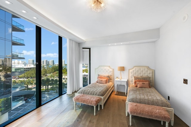 sitting room with floor to ceiling windows and wood-type flooring