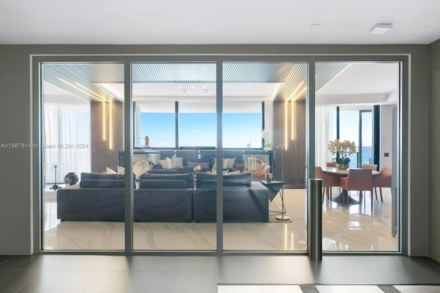 living room featuring light tile flooring and a water view