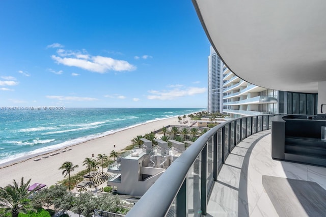 balcony featuring a water view and a beach view