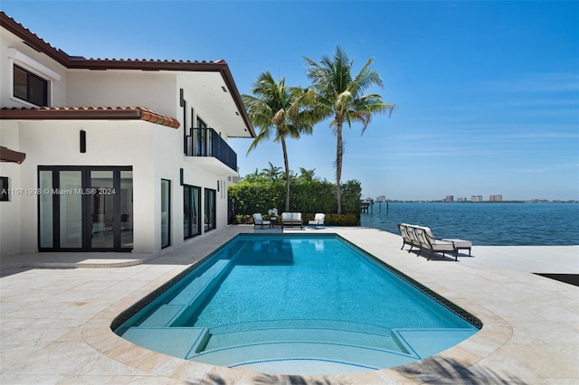 view of pool with french doors, a water view, and a patio area