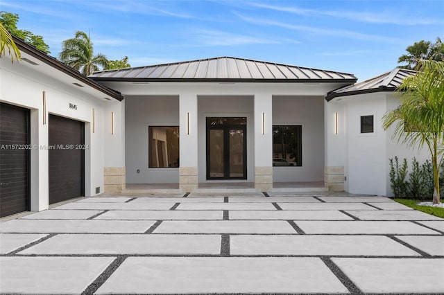 view of exterior entry featuring a garage and a patio