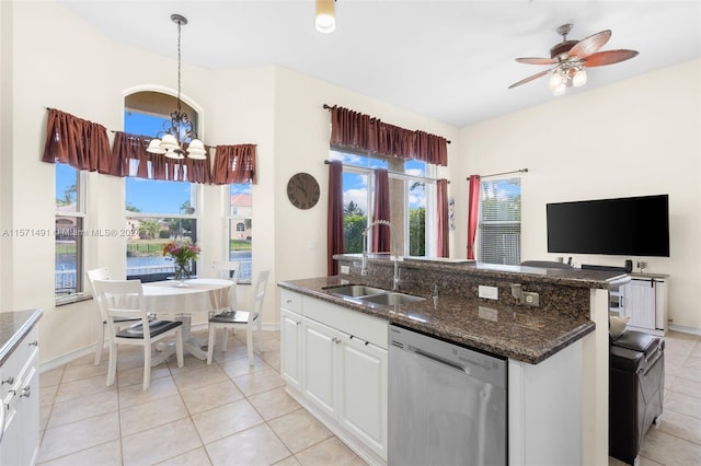 kitchen with light tile patterned floors, white cabinets, decorative light fixtures, stainless steel dishwasher, and sink