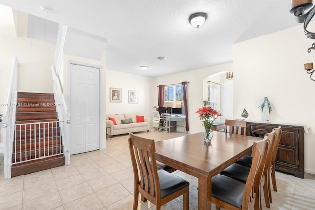 dining area featuring a textured ceiling and light tile patterned floors