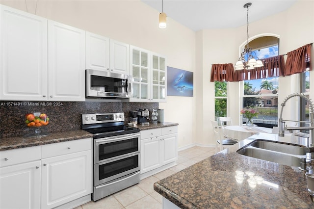 kitchen featuring white cabinetry, hanging light fixtures, and appliances with stainless steel finishes