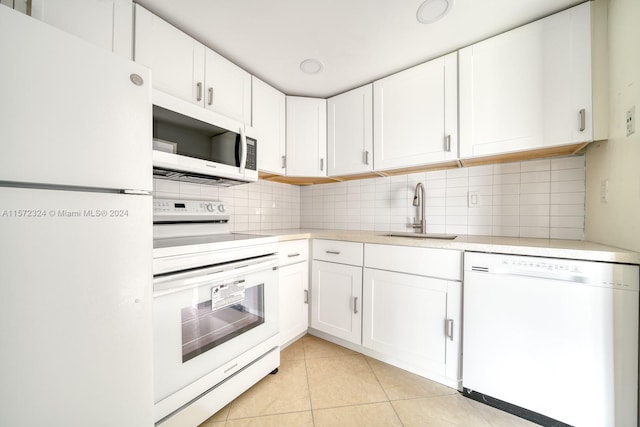 kitchen featuring white appliances, tasteful backsplash, white cabinets, sink, and light tile floors