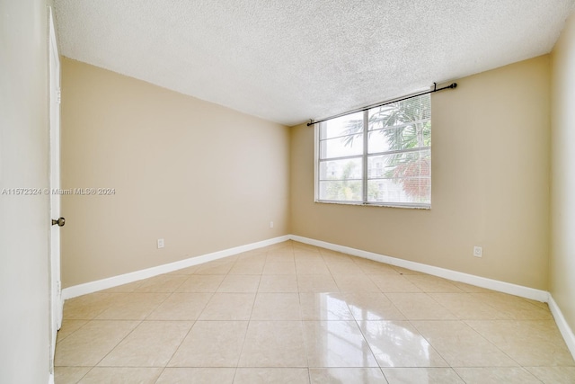 tiled spare room with a textured ceiling