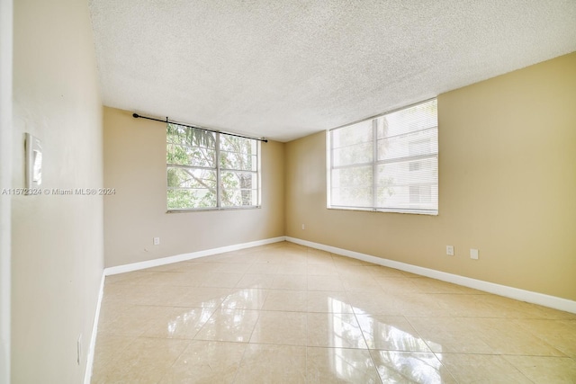 spare room featuring a textured ceiling and light tile floors