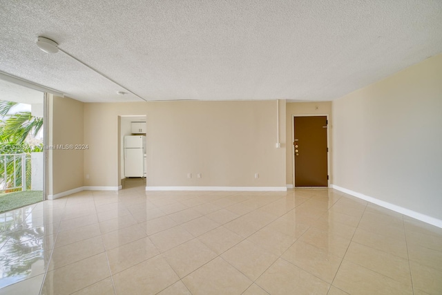 tiled spare room featuring a textured ceiling