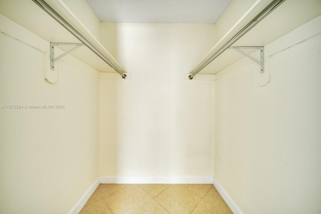 walk in closet featuring light tile floors