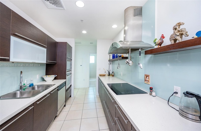 kitchen with dark brown cabinets, appliances with stainless steel finishes, backsplash, island range hood, and sink