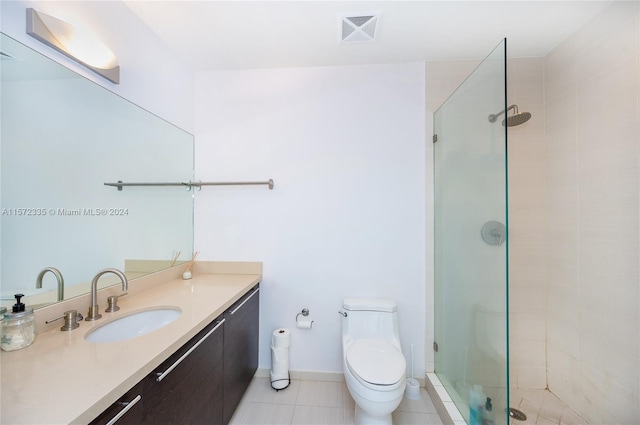 bathroom featuring an enclosed shower, vanity, tile floors, and toilet