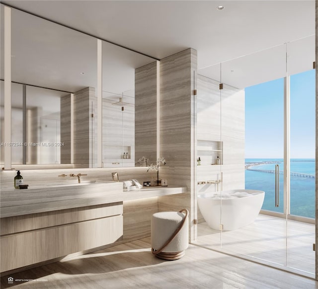 bathroom with independent shower and bath, tile walls, a water view, and a wealth of natural light