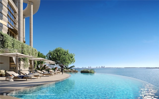 view of swimming pool with a water view and a patio area