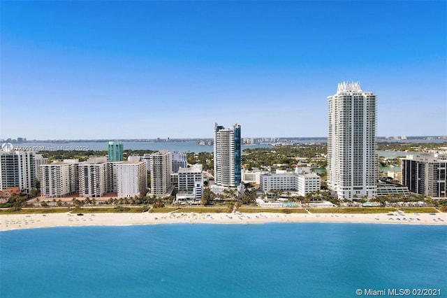 drone / aerial view with a view of city, a water view, and a view of the beach