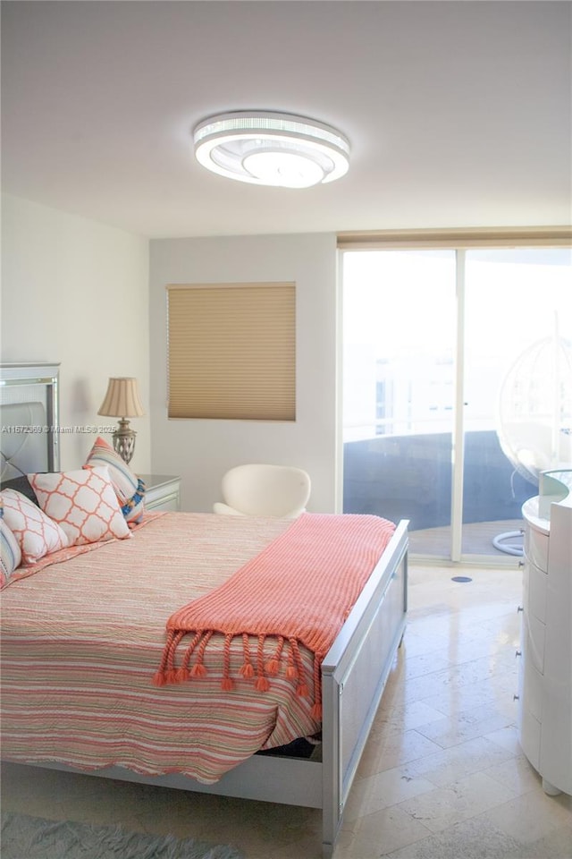 bedroom featuring a wall of windows and access to exterior