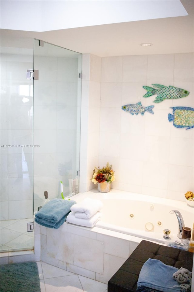 full bath featuring tile patterned flooring, tile walls, and a whirlpool tub