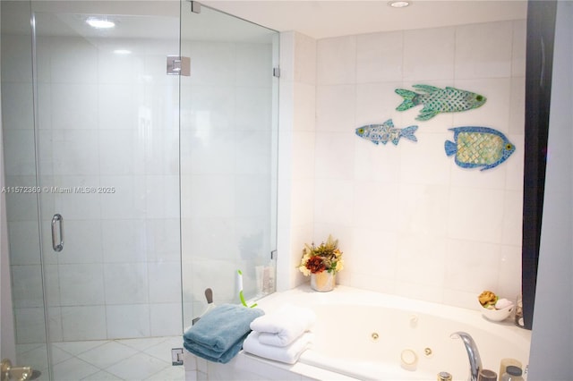 full bathroom featuring tile walls, a shower stall, and a tub with jets