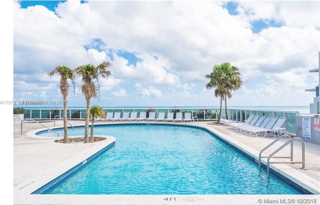 community pool featuring a patio area and a water view