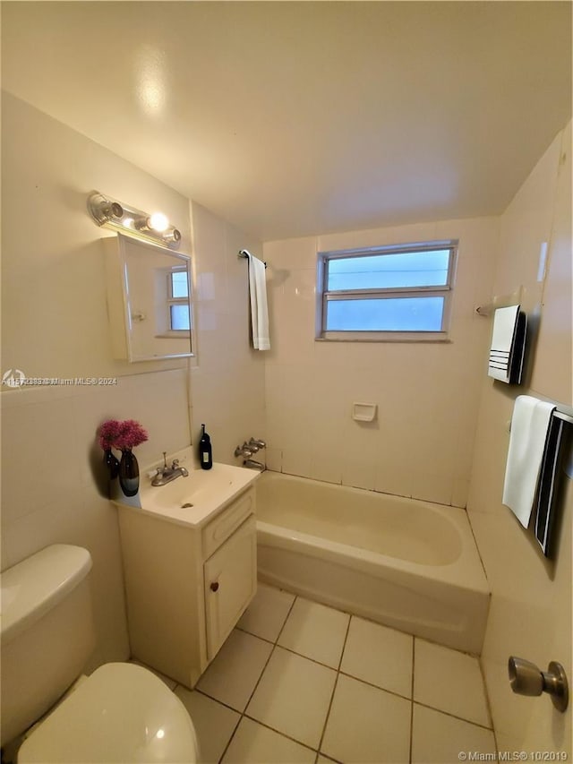 full bathroom featuring tile flooring, tiled shower / bath, large vanity, and toilet