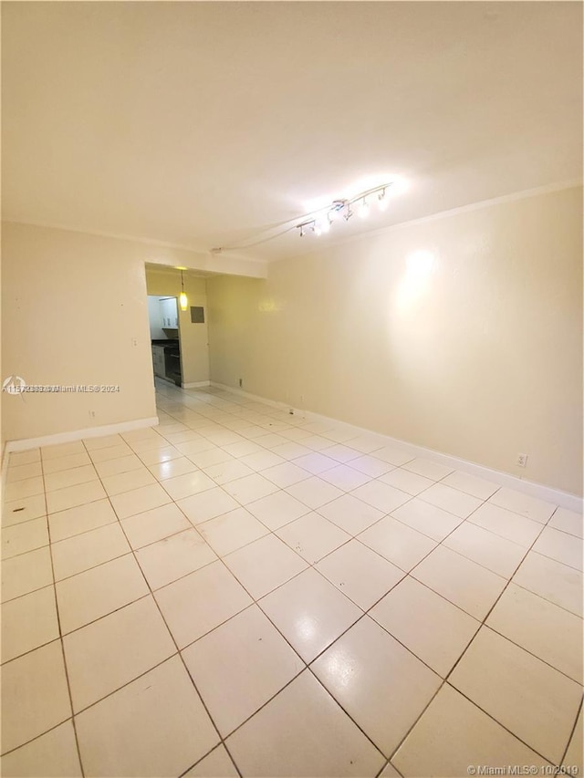 empty room with track lighting and light tile floors