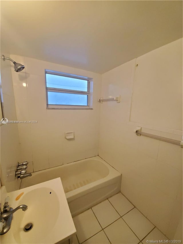 bathroom featuring tile floors, tiled shower / bath, and sink