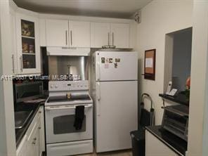 kitchen featuring white cabinets and white appliances