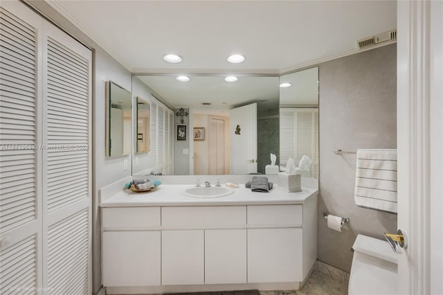 bathroom featuring ornamental molding, toilet, and vanity