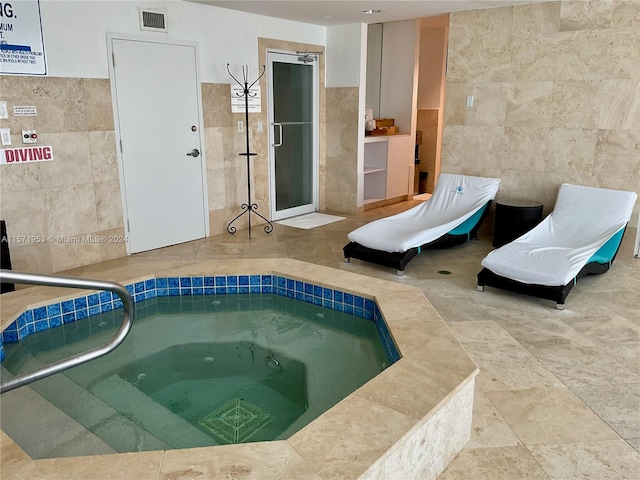 view of pool with an indoor hot tub